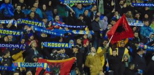 kosovo football fans wave flags in stadium